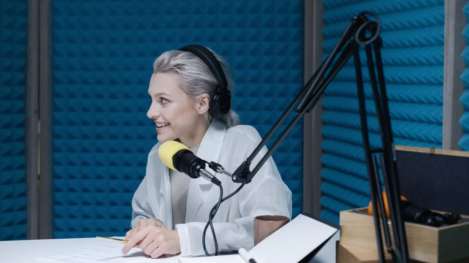 A podcaster at a microphone in a bright home studio